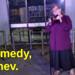 A woman outside Point Chev library tells jokes into a microphone