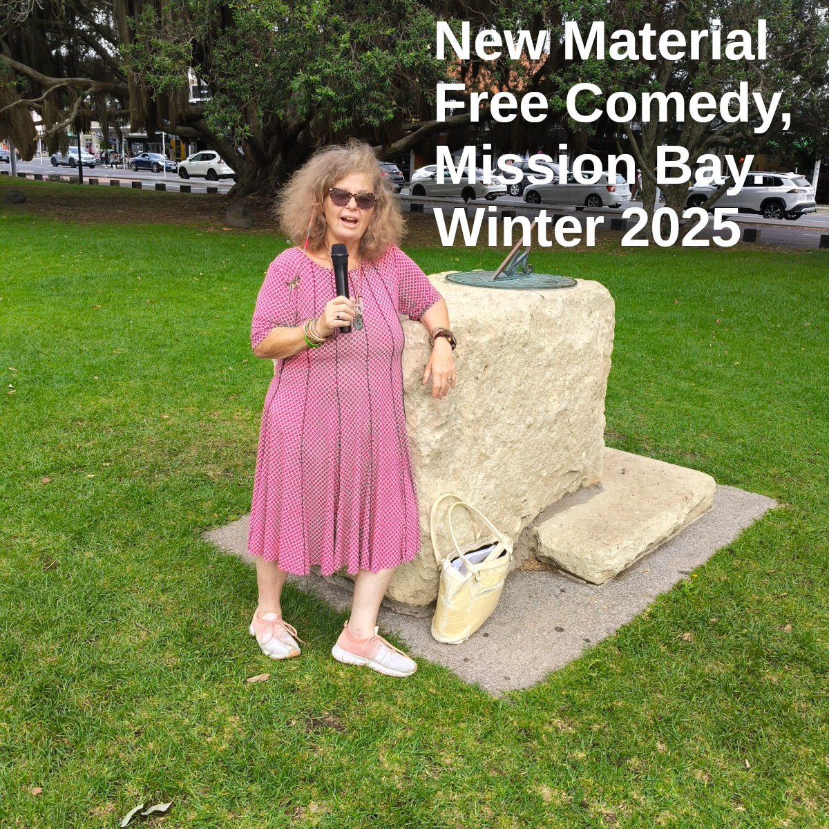 Tessa with microphone by the sundial in Selwyn Domain, Mission Bay. Text: New Material Free Comedy, Mission Bay. Winter 2025