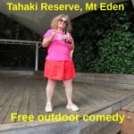 Tessa with microphone on the wooden stage at Tahiki Reserve, Mt Eden