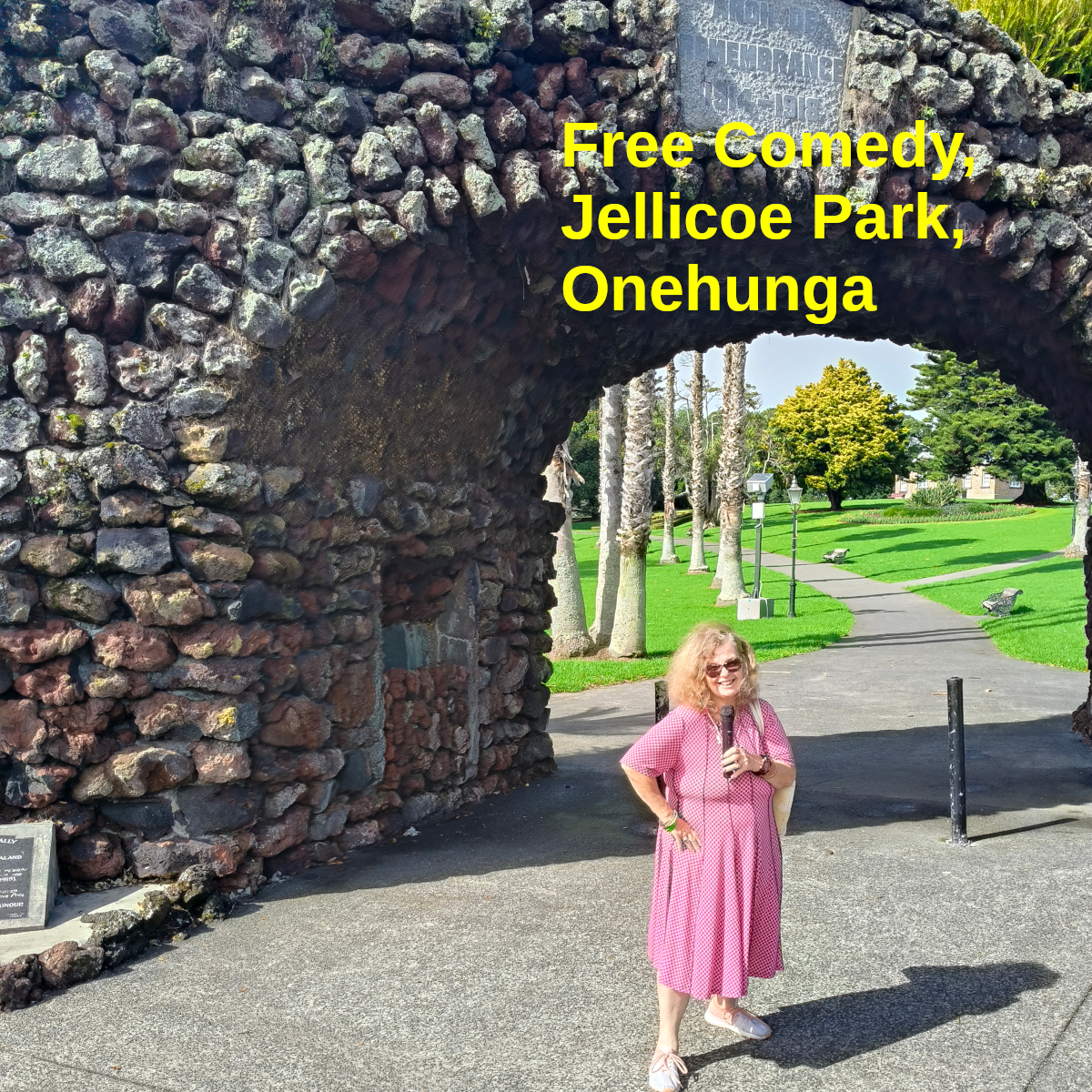 Tessa, mic in hand, stands in front of the memorial arch at Jellicoe Park, Onehunga